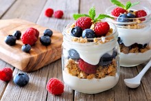 Blueberry And Raspberry Parfaits In Mason Jars, Scene On A Rustic Wood Background