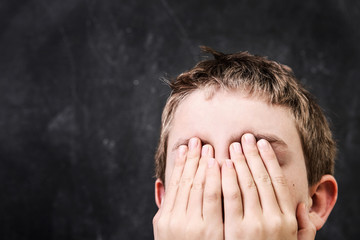 Student with his hands over his face