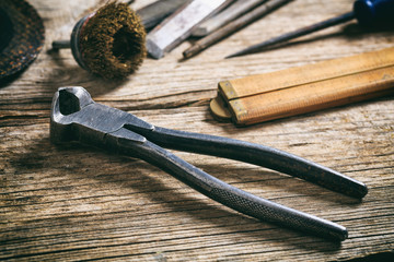 Old plier on wooden background