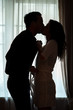 © DenisProduction.com - Couple kissing near window. People undressing each other. Ignite the fire of passion.