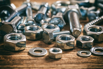 Wall Mural - Bolts and nuts on wooden background