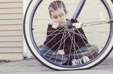Sad Boy Looking At His Flat Bike Tire