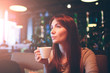 © estradaanton - Hot mug of tea with woman hands. beautiful female cup coffee on the restaurnt . Red hair girl
