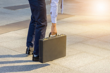 Young business man standing with his back carrying a briefcase c