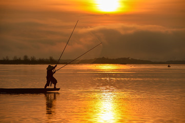 The silluate fisherman boat in river  on during sunrise,Thailand