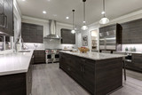 Fototapeta  - Modern gray kitchen features dark gray flat front cabinets paired with white quartz countertops and a glossy gray linear tile backsplash. Northwest, USA.