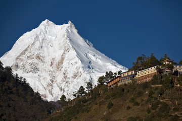 Wall Mural - buddhist monastery in front of peak of manaslu - one of the highest mountains in the world.