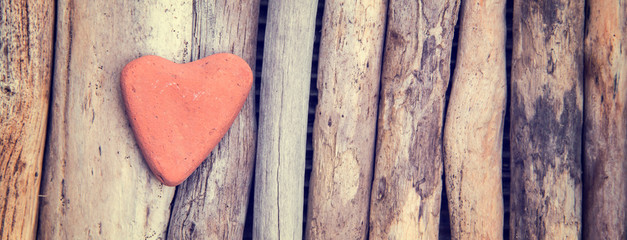 Wall Mural - red stone in the shape of a heart on wood background, vintage process