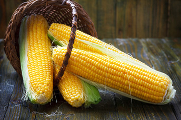 Fresh corn on cobs on rustic wooden table, closeup