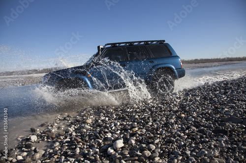 Fotografia  auto fuoristrada mentre guada un fiume
