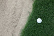 © charnsitr - golf ball on the grass near the sand bunker