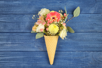 Poster - Waffle cone with composition of beautiful flowers on wooden background