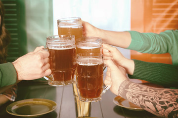 Wall Mural - Hands of people with beer celebrating Saint Patrick's Day in pub