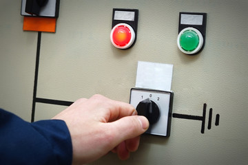 Hand a man in overalls includes an electric switch