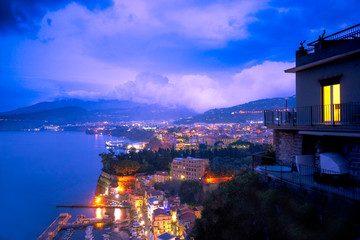 Wall Mural - Beautiful night view of Italy's Amalfi coast lit up at night from Sorrento towards Naples.