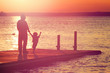 © soupstock - Father and son walking out on a dock at sunset