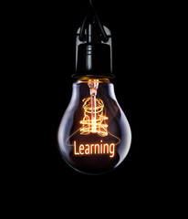 Hanging lightbulb with glowing Learning concept.