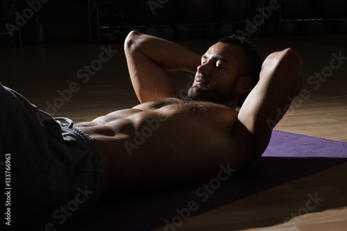 Fotografie, Obraz Fitness model exercising sit ups and crunches. Muscular well bui
