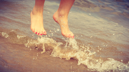 Canvas Print - Female feet jump on beach.