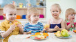 © Andrey Kuzmin - funny kids eating fruits in kindergarten dinning room