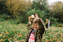 Young Girl Throwing Autumn Leaves 