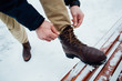 Shoelaces of boots. Man tying shoelaces on winter boots in winter day