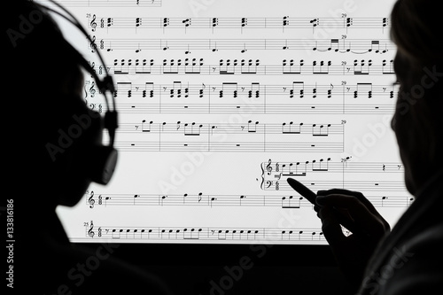 Cuadros en Lienzo Two people working on a musical score using computer notation software