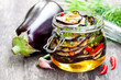 Grilled  sliced eggplant with chili in glass jar on rustic table
