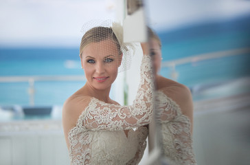 Closeup Portrait of beautiful bride on elegant white dress - soft focus. Wedding hairstyle and Bridal make up.