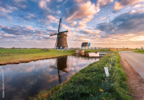Foto Windmill near the water canal at sunrise in Netherlands