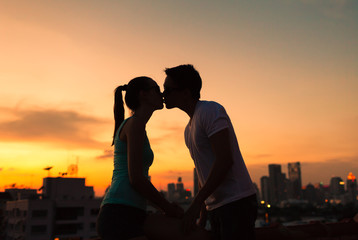 Wall Mural - Young couple kissing in the city. 