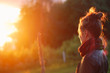 Young woman looking at glowing sunset flare
