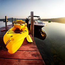 Sunrise Over Kayaks And Boats Tied Up Awaiting Summer Fun At The Lake