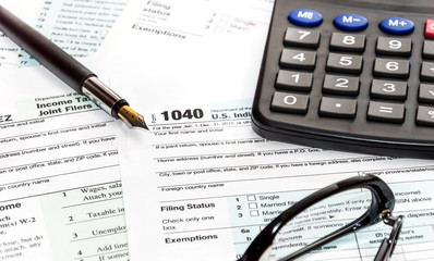 Wall Mural - Pen, glasses and calculator on tax form 1040. business concept.