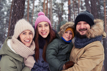 Wall Mural - Funny family of 4 members smiling and laughing during the winter