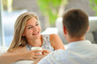 © schamin - Handsome long haired young blonde woman sitting on a couch propped her head with one hand and holding a mug of delicious tea in another hand, in love looking at her husband