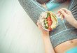 Young woman is resting and eating a healthy salad after a workout. Fitness and healthy lifestyle concept.