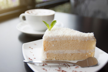 Wall Mural - Hot cappuccino and cake on a black table.