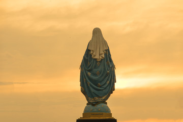 Wall Mural - Virgin mary statue warm tone sunset scene