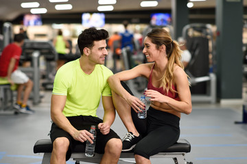 Man and woman drinking water after workout