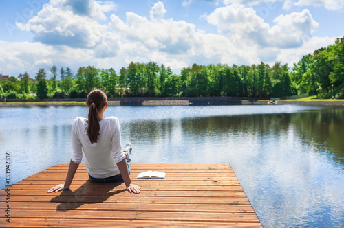 Cuadros en Lienzo Woman relaxing by a beautiful lake.