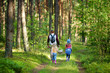 © MNStudio - Two cute little sisters hiking in a forest with their grandmother