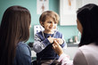 © Cavan Images - Smiling boy listening to his heartbeat with doctor and mother in clinic