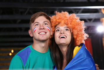 Wall Mural - Cheerful friends with France flag emotionally watching soccer game in sport bar