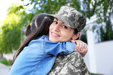 Mother in army uniform and daughter in the street