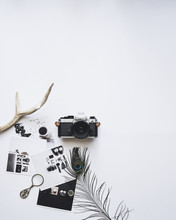 Overhead View Of Camera And Photographs On White Background