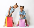 © Africa Studio - Two cute African girls with shopping bags on white background