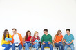 © Africa Studio - Group of people reading books while sitting near light wall