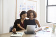 © Cavan Images - Happy businesswomen using tablet computer in board room