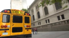Yellow School Bus Parked On A New York City Street In Front Of The Public Library Building 